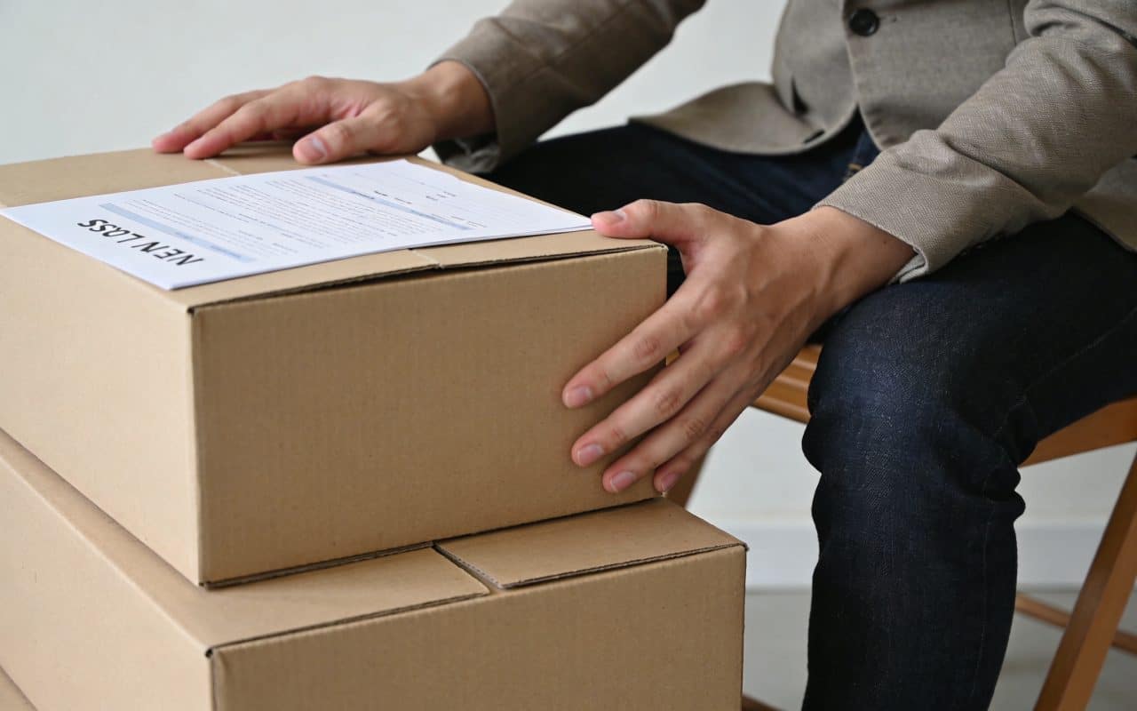 Locataire assis devant cartons de demenagement et nouveau bail