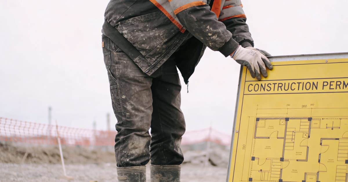 ouvrier examinant un panneau jaune permis de construire