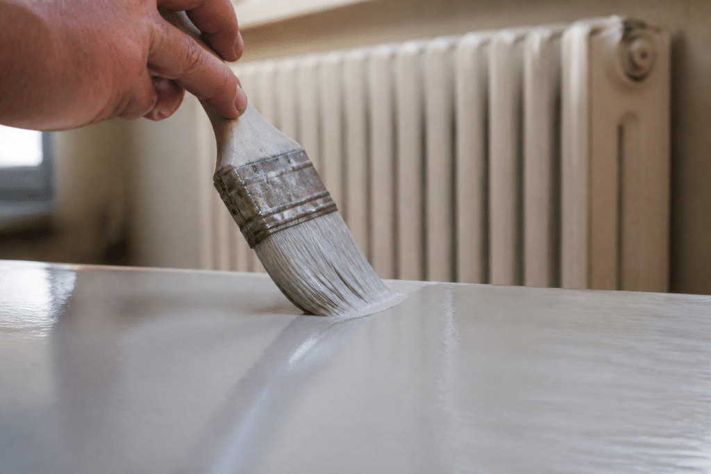 Pinceau humide sur surface brillante avec radiateur chauffant en arriere-plan