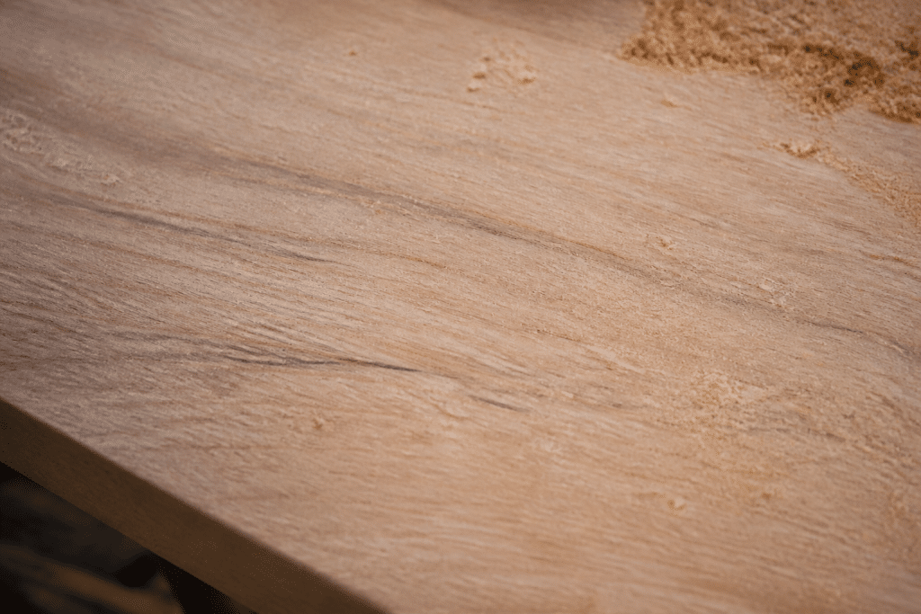 Surface de bois poncee avec grain visible et poussiere
