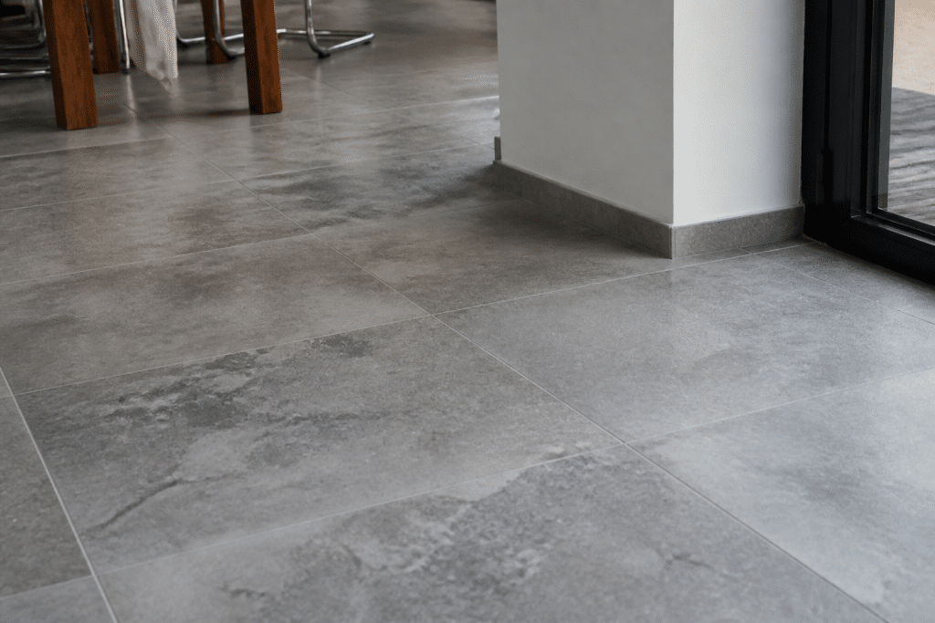 Carrelage gris aspect pierre posé sur sol intérieur