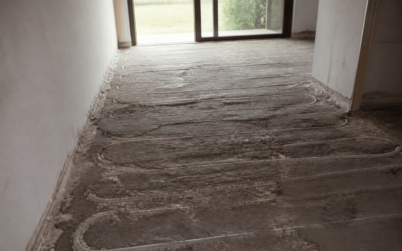 couche de chape grise recouvrant tubes chauffants apparents