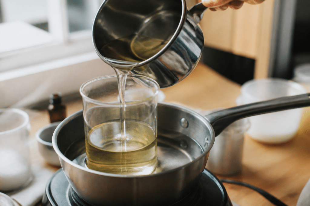 Cire liquide claire versée dans récipient transparent chauffé