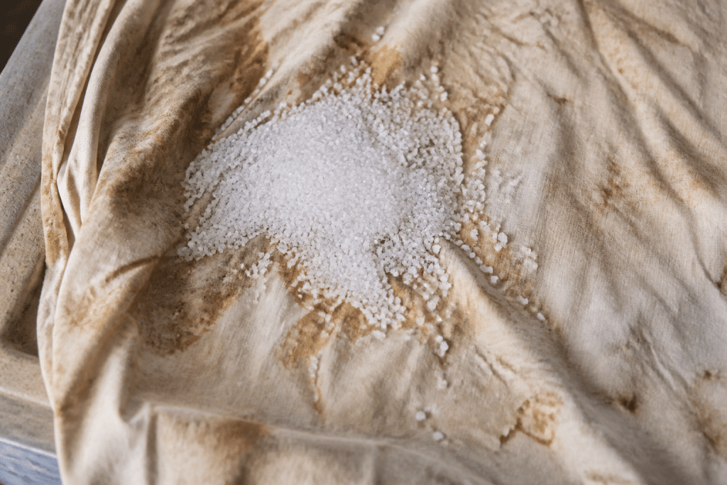 Cristaux blancs versés sur tissu jauni et taché