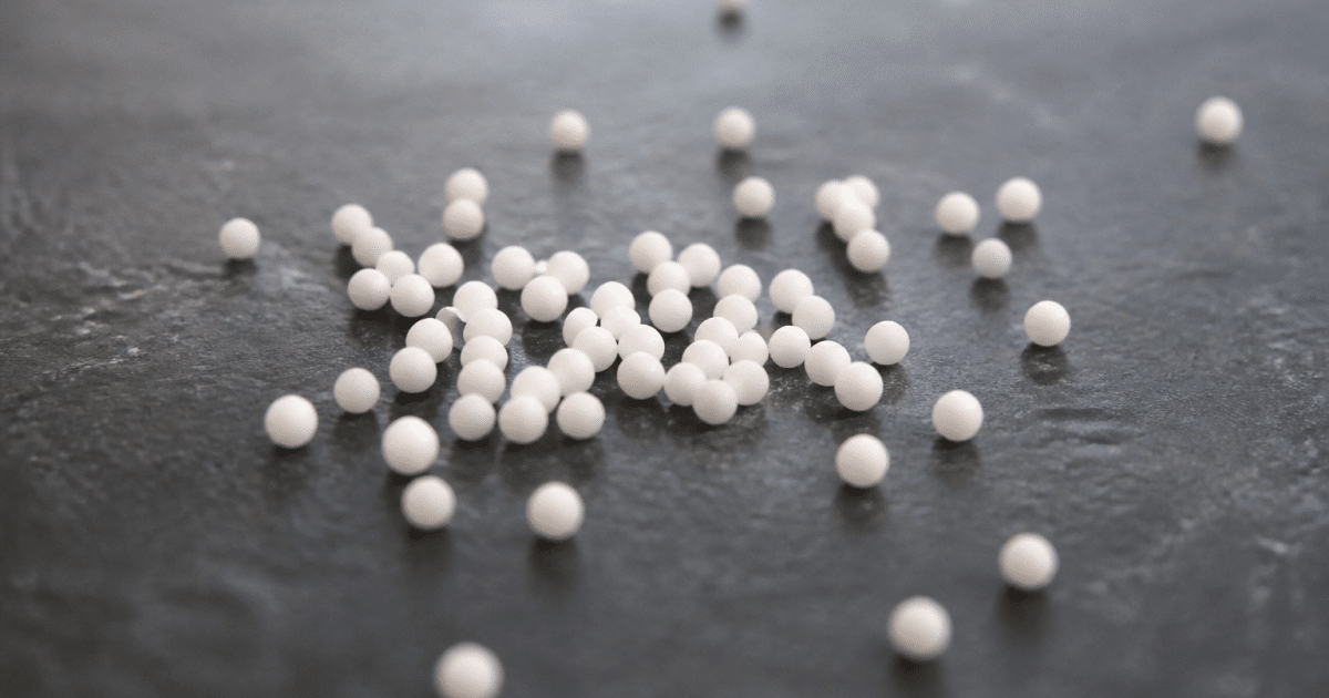 Petits granules homeopathiques blancs disposes sur surface plane