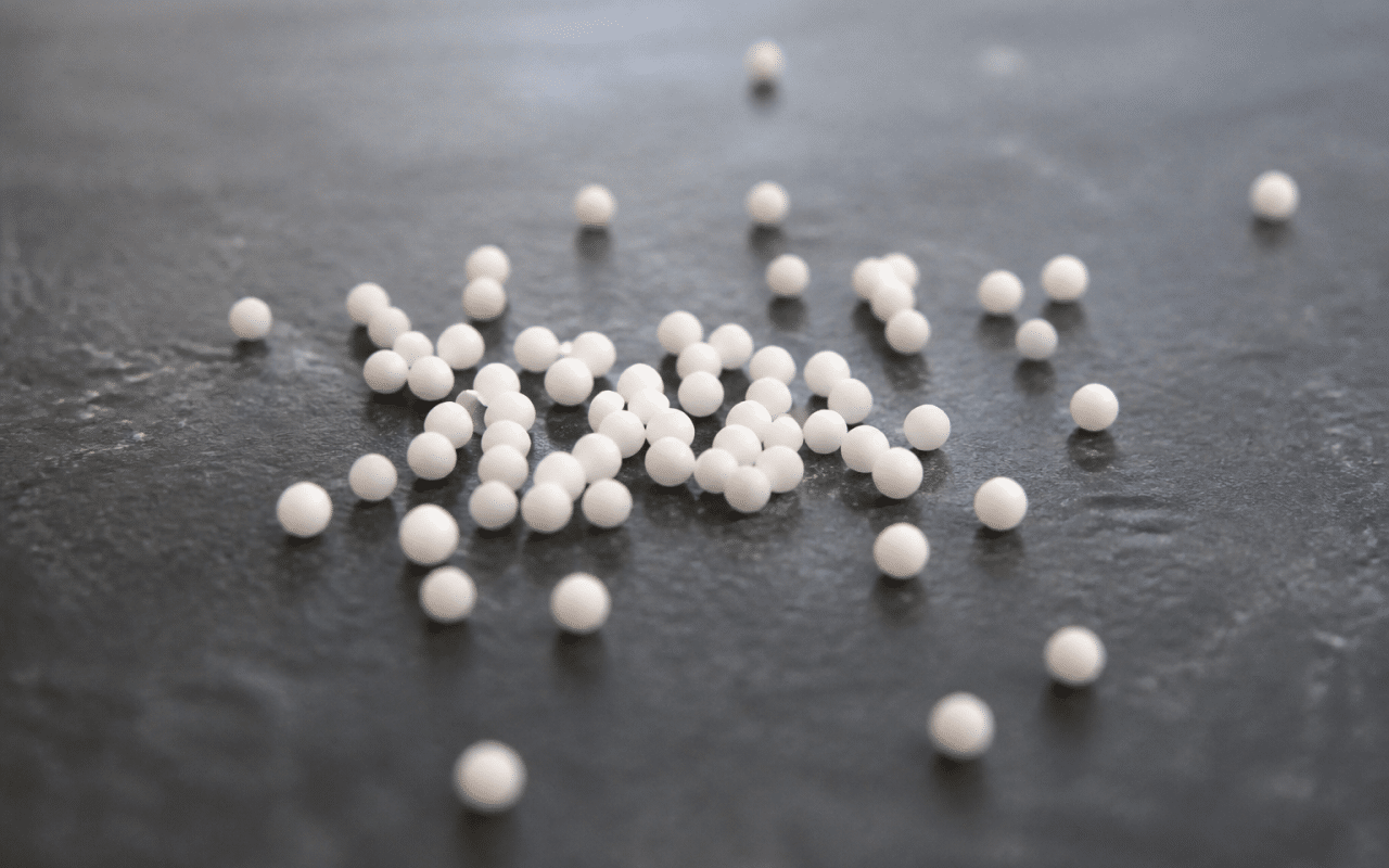 Petits granules homeopathiques blancs disposes sur surface plane