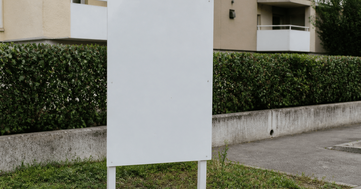 Annonce immobiliere affichee sur panneau blanc vertical exterieur