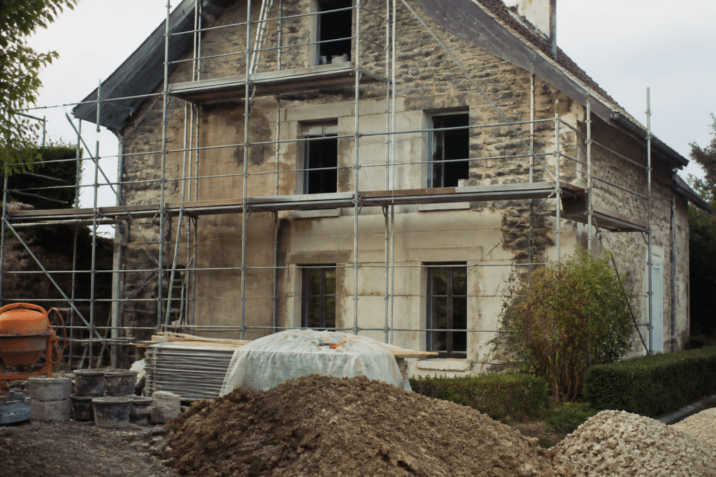 Maison en renovation avec echafaudages et materiaux de chantier