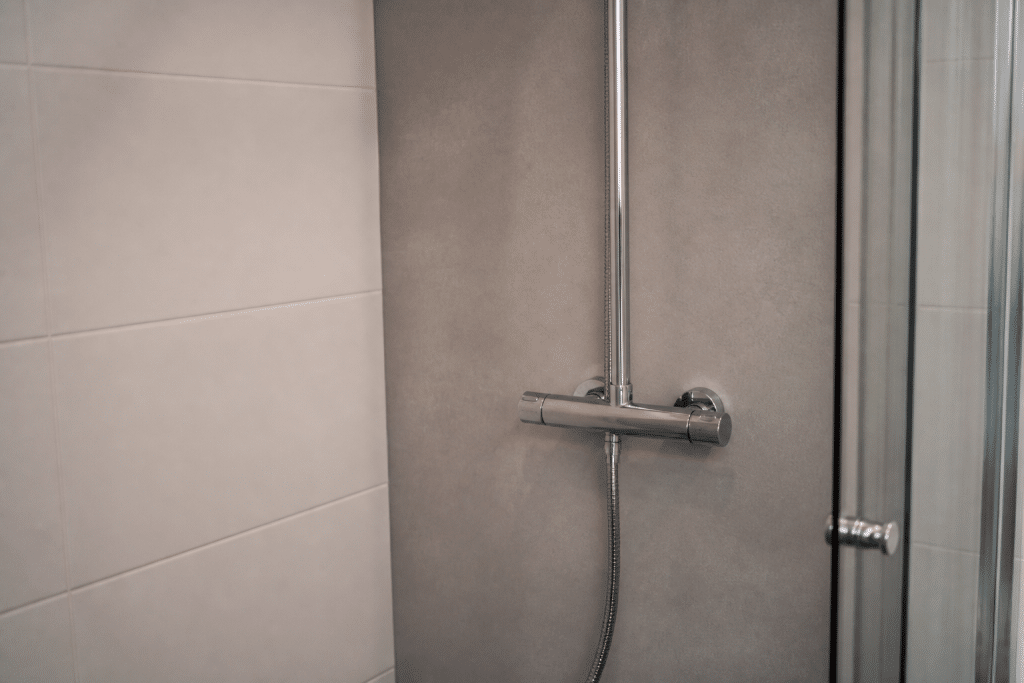 Plaque hydrofuge grise derriere douche carrelage blanc