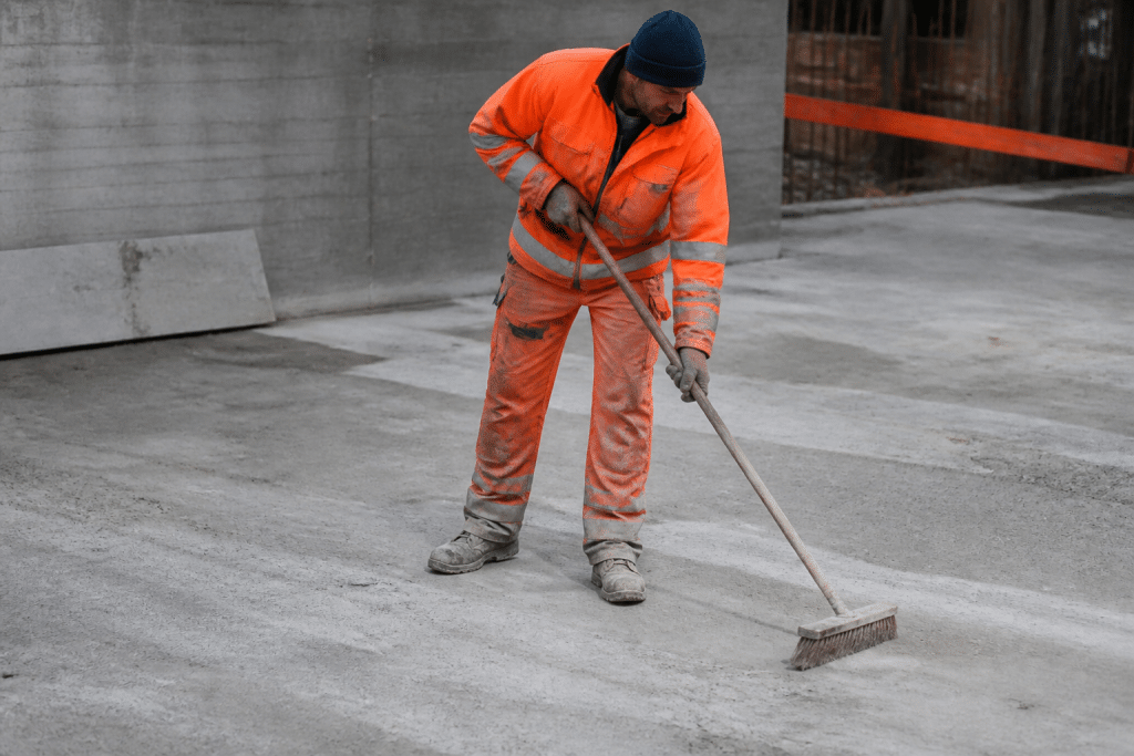 Ouvrier prepare surface beton grise avec brosse nettoyage