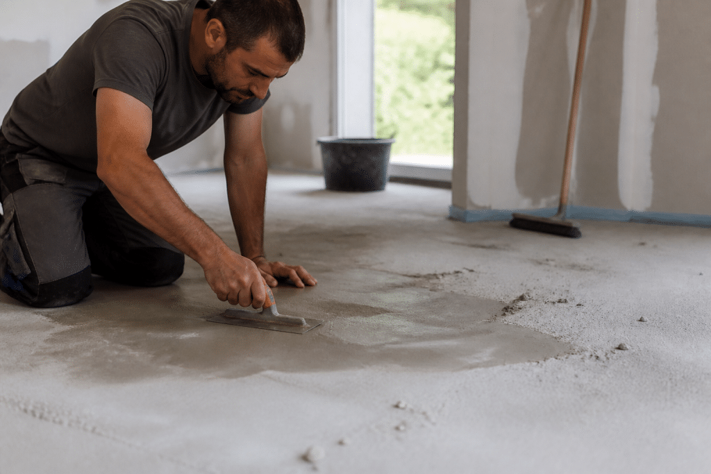 Ouvrier préparant surface avant installation carrelage rectifié