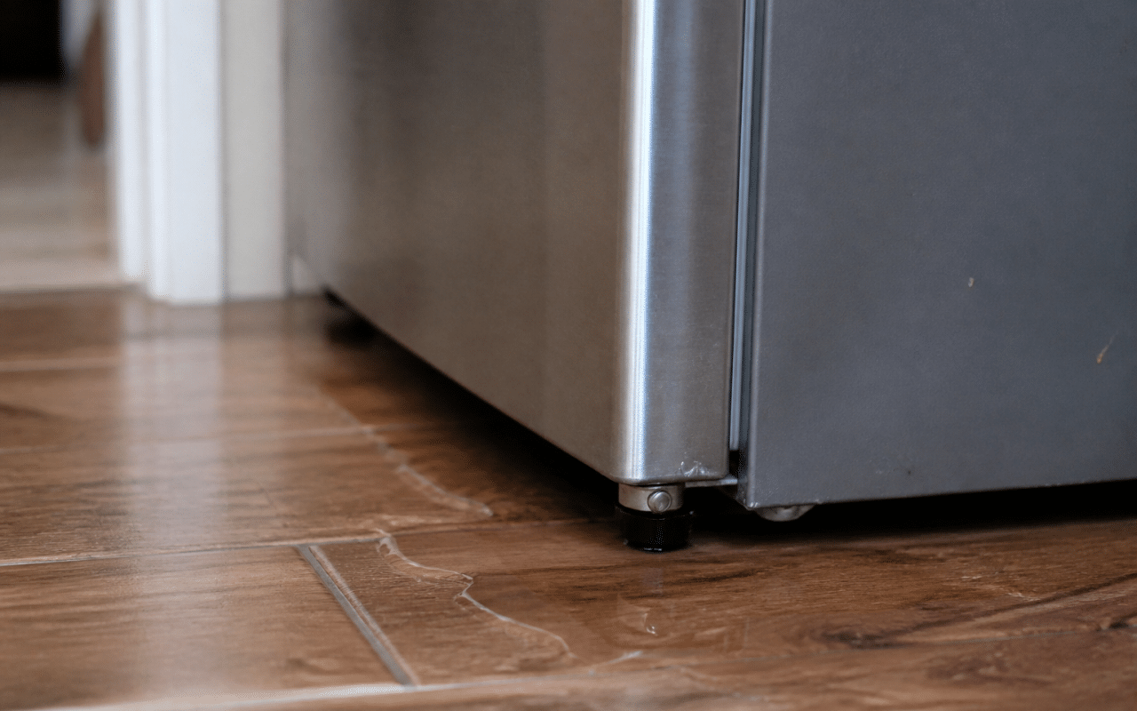 Refrigerator with water pooling beneath its base