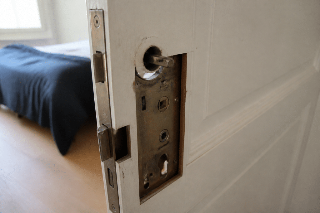 Mécanisme de serrure encastrée partiellement démonté sur porte