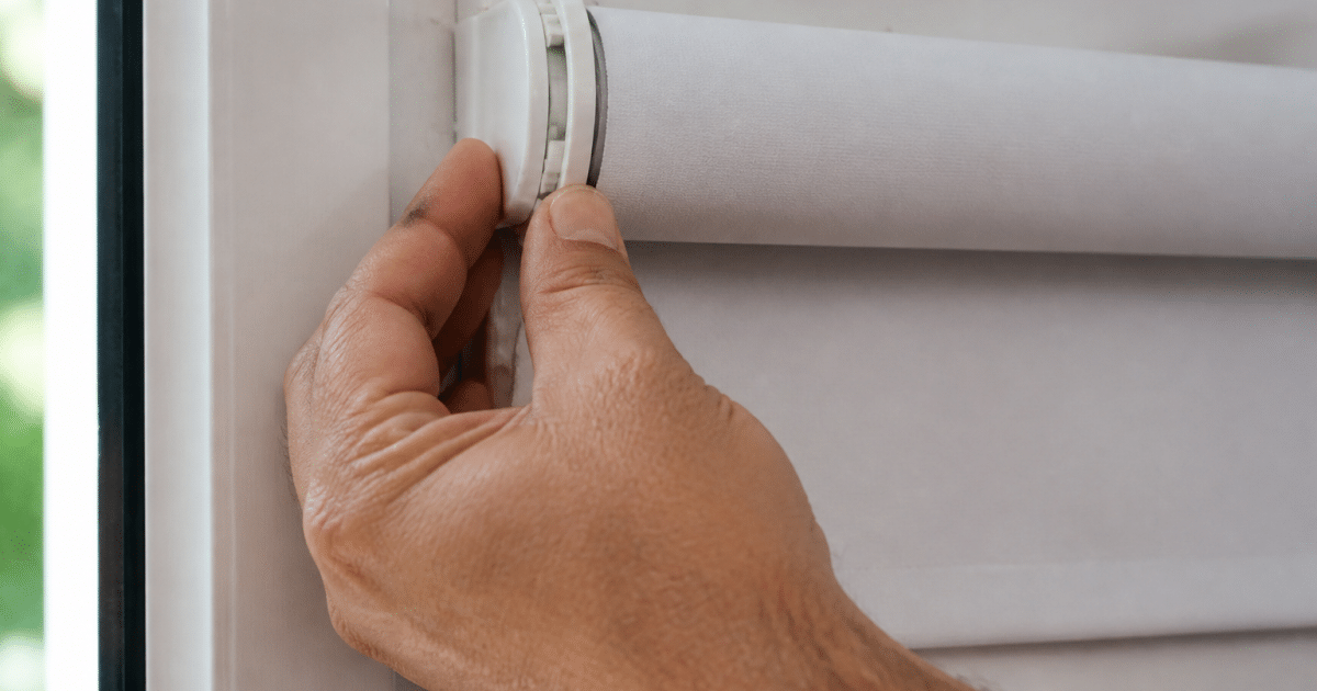 Mains serrant mecanisme enroule d'un store vertical blanc